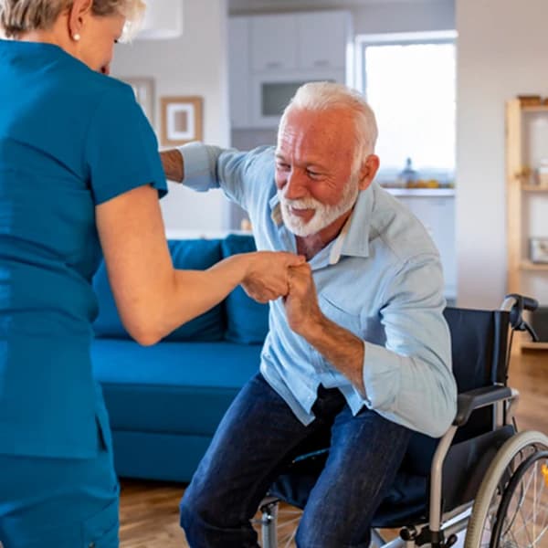 Carer helping an elderly man in a wheelchair