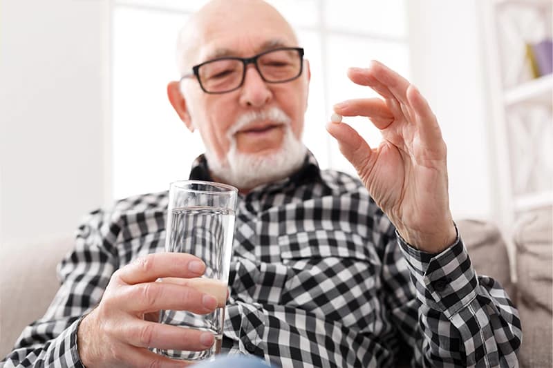 Old man taking pills