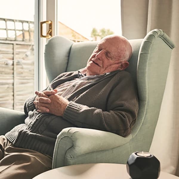 Retired senior adult sleeping on chair