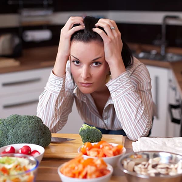 A frustrated woman looking out at salad bowls