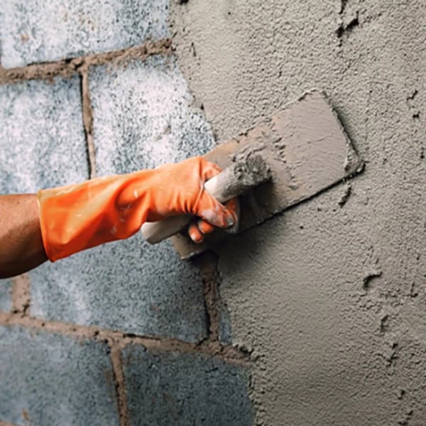 Closeup hand worker plastering cement on wall