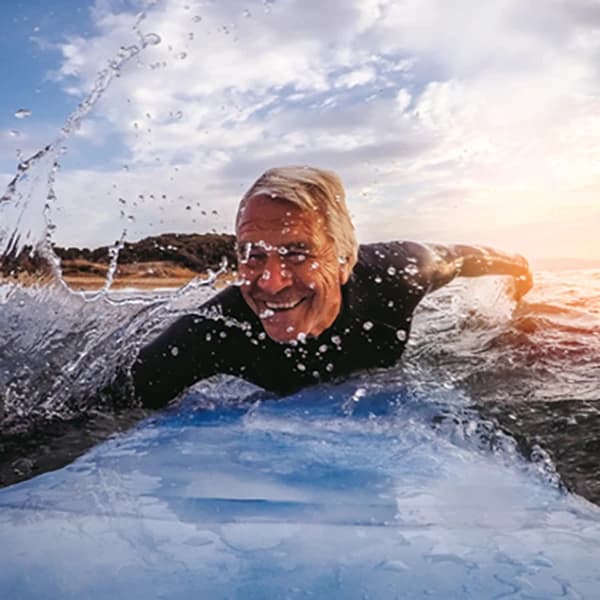 Happy senior man surfing