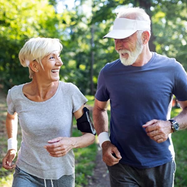 Happy fit senior couple exercising in park