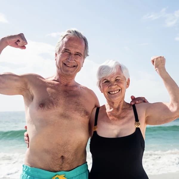 Happy senior couple flexing their muscle